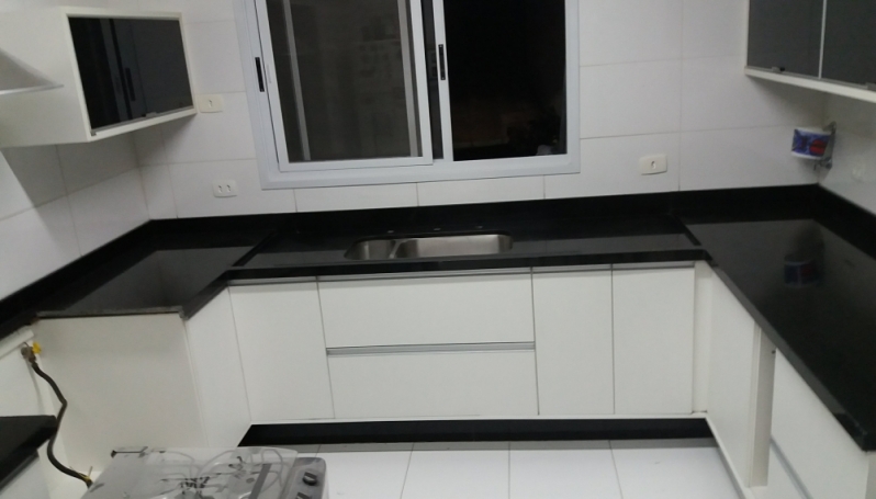 cozinha com bancada de granito preto e madeira